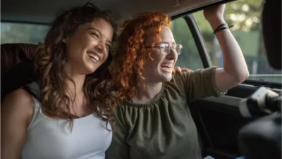 Happy women couple traveling by car